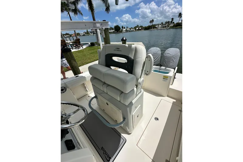 Slide: The Image of 2021 Cobia 240 Center Console boat interior with helm seat and waterfront view. - 52