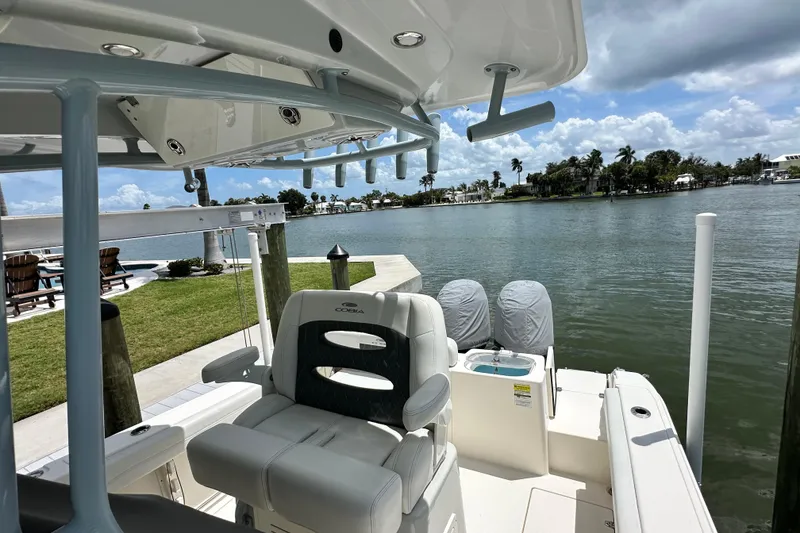 Slide: The Image of 2021 Cobia 240 Center Console boat docked by a scenic waterfront. - 53