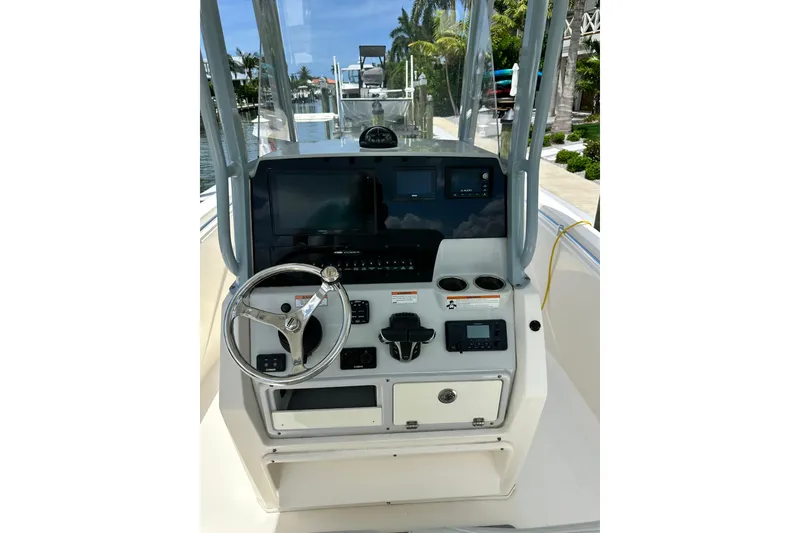 Slide: The Image of 2021 Cobia 240 Center Console boat dashboard with steering wheel and navigation controls. - 63