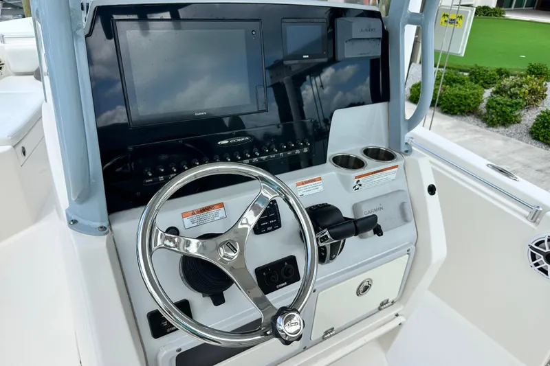 Slide: The Image of 2021 Cobia 240 Center Console boat dashboard with steering wheel and Garmin display. - 66