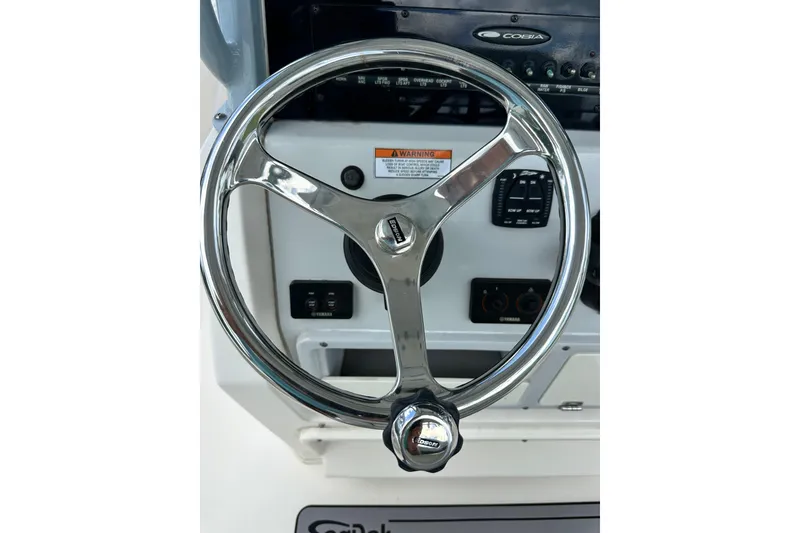 Slide: The Image of Steering wheel of a 2021 Cobia 240 Center Console boat, featuring control panel. - 67