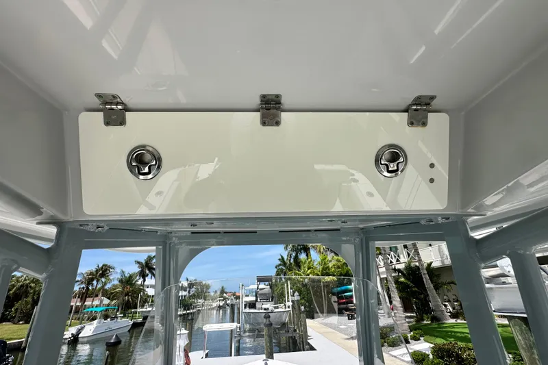 Slide: The Image of 2021 Cobia 240 Center Console boat interior with storage compartment and scenic marina view. - 76