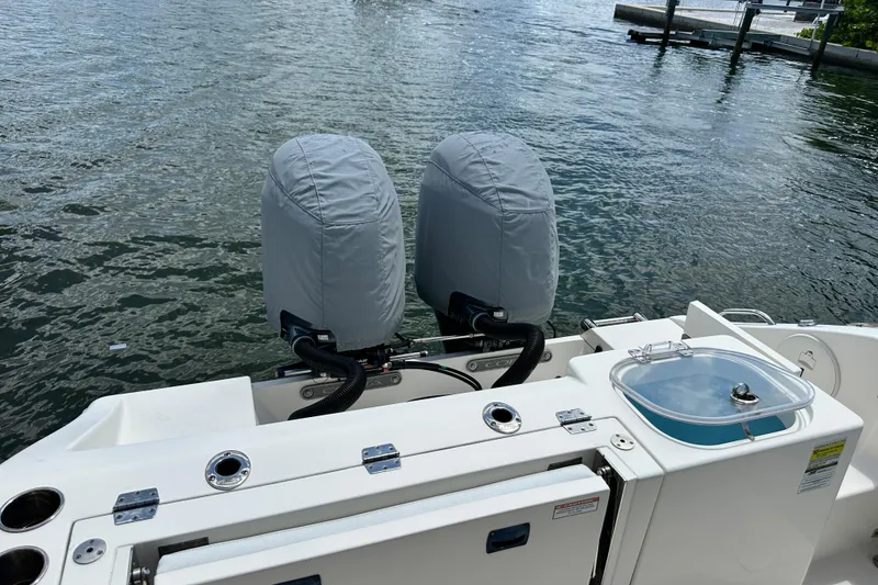 Slide: The Image of 2021 Cobia 240 Center Console boat with covered dual engines on calm water. - 8