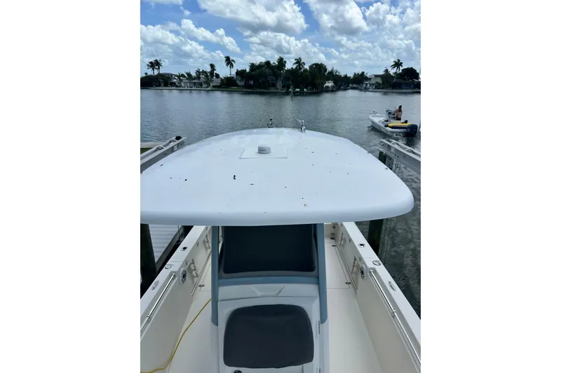 Slide: The Image of 2021 Cobia 240 Center Console boat docked by a scenic waterfront. - 84