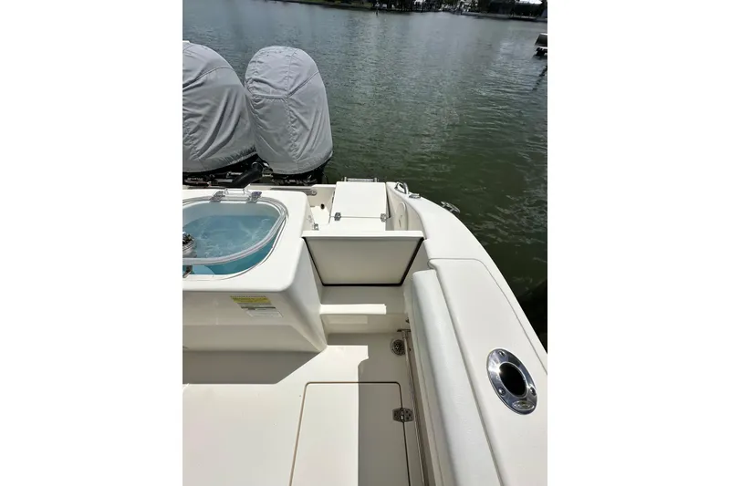 Slide: The Image of 2021 Cobia 240 Center Console boat with covered engines on a calm lake. - 85