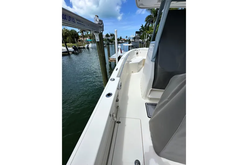 Slide: The Image of 2021 Cobia 240 Center Console boat docked by a scenic waterfront. - 87