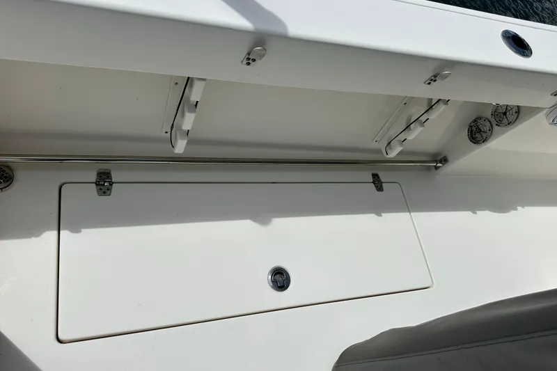 Slide: The Image of 2021 Cobia 240 Center Console boat deck with storage compartment and rod holders. - 88