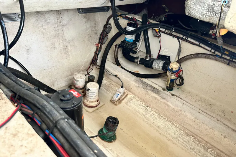 Slide: The Image of Bilge area of a 2021 Cobia 240 Center Console boat, showing wiring and pumps. - 96
