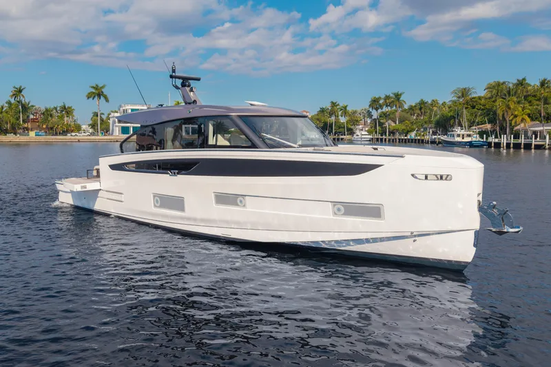 Slide: The Image of 2025 Azimut Seadeck 6 yacht cruising on a sunny day, surrounded by palm trees. - 16