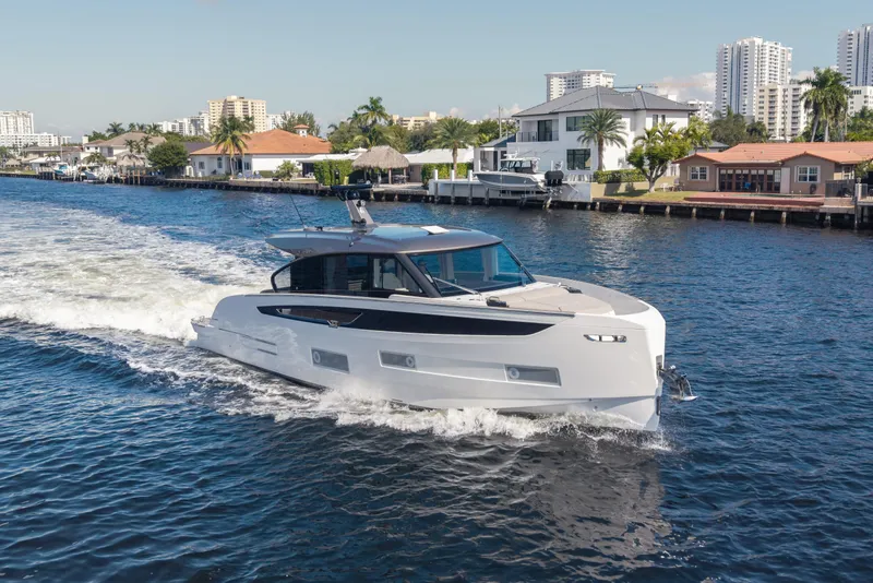 Slide: The Image of 2025 Azimut Seadeck 6 yacht cruising on a scenic waterway near luxury homes. - 17