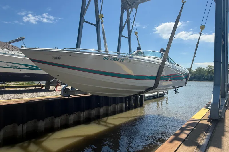 The Image of 1999 Formula 312 FASTech boat being lifted by a crane near the water. - 0