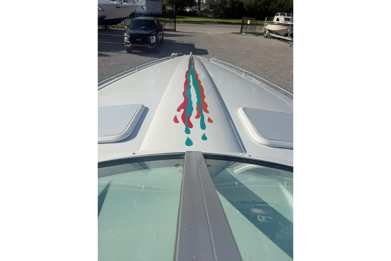 Slide: The Image of 1999 Formula 312 FASTech boat with colorful stripe design on deck, parked in marina. - 1