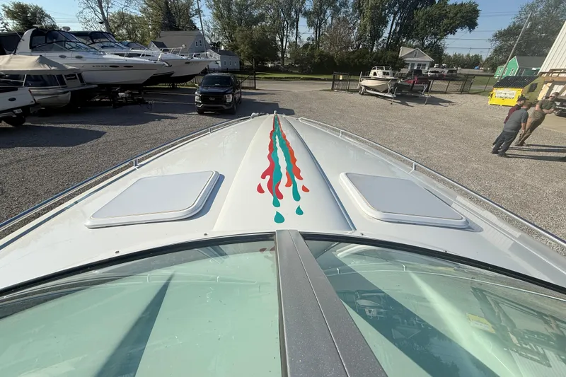 Slide: The Image of 1999 Formula 312 FASTech boat with colorful deck design in a marina setting. - 2