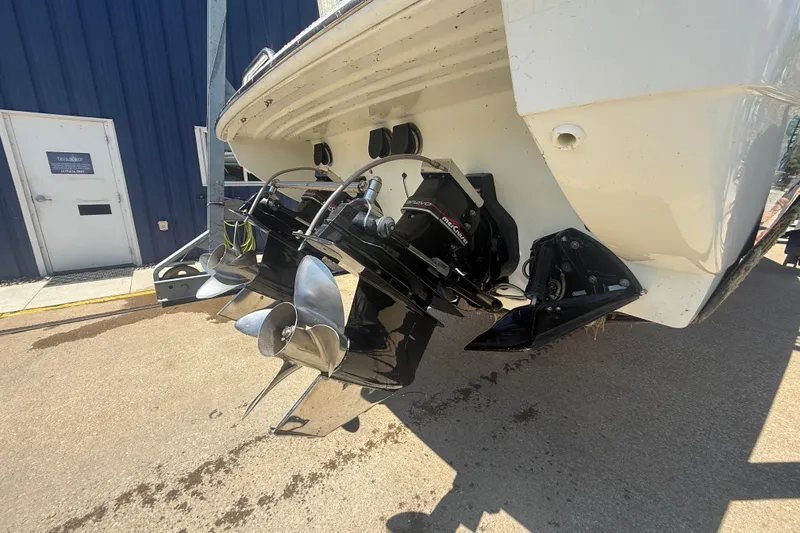Slide: The Image of 1999 Formula 312 FASTech boat with dual propellers, parked near a blue building. - 22