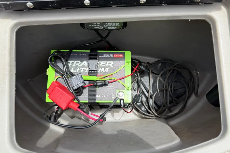Slide: The Image of Battery compartment of 2022 Sun Tracker Bass Buggy 16 DLX with lithium battery and cables. - 16