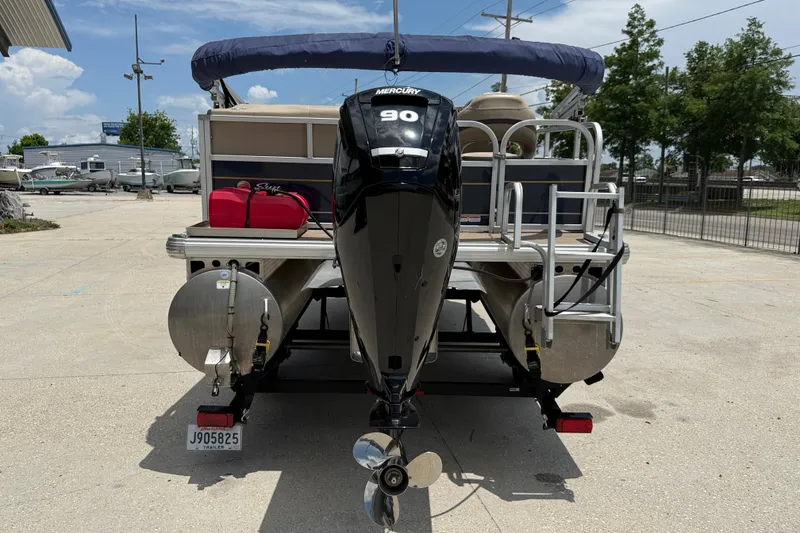 Slide: The Image of 2022 Sun Tracker Bass Buggy 16 DLX pontoon boat with Mercury 90 engine, parked outdoors. - 4