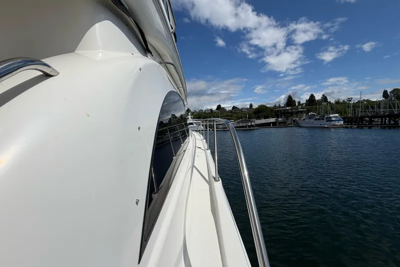 Slide: The Image of 2005 Meridian 411 Sedan yacht docked by a scenic waterfront under a blue sky. - 21