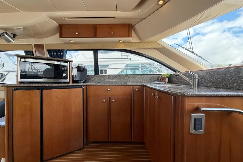 Slide: The Image of Luxurious 2005 Meridian 411 Sedan yacht kitchen with wood cabinetry and modern appliances. - 7
