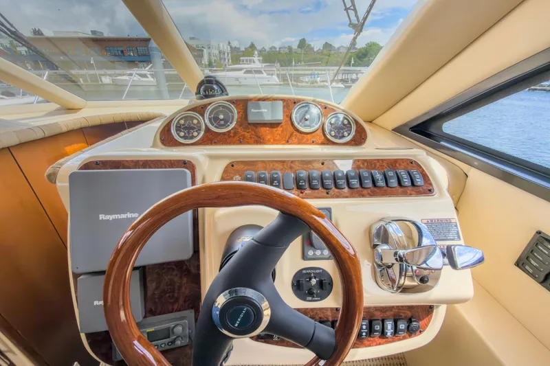 Slide: The Image of 2005 Meridian 411 Sedan helm with Raymarine navigation, wood accents, and modern controls. - 9