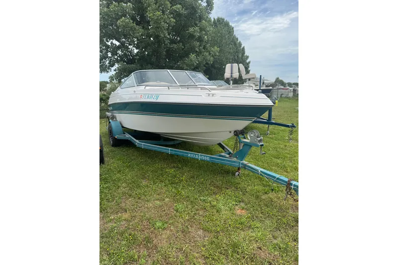 Slide: The Image of 1994 Four Winns 200 Horizon boat on trailer, parked on grassy area. - 1