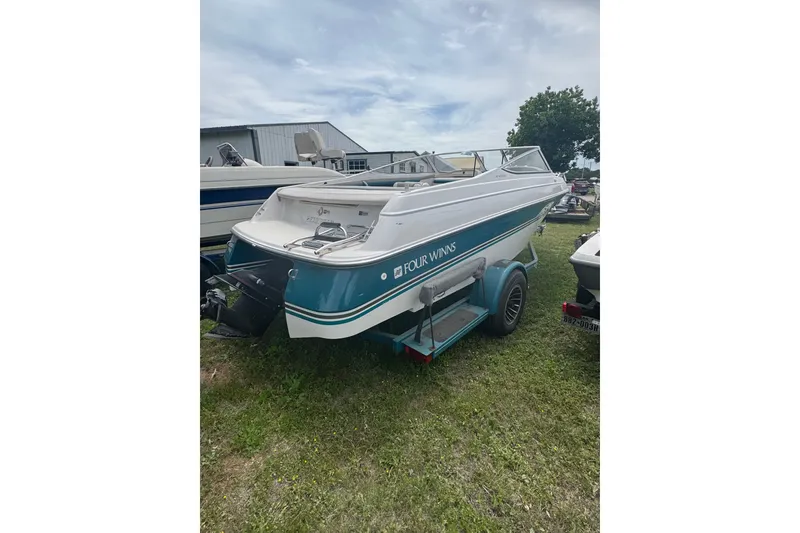 Slide: The Image of 1994 Four Winns 200 Horizon boat on trailer, parked on grass near other boats. - 2