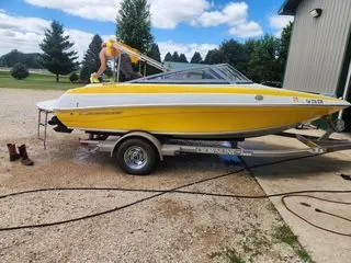 The Image of Yellow 2012 Crownline 18 SS boat on trailer, parked outdoors. - 1