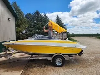 Slide: The Image of Yellow 2012 Crownline 18 SS boat on trailer, person setting up canopy. - 3