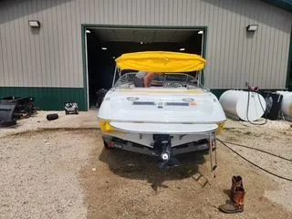 Slide: The Image of 2012 Crownline 18 SS boat with yellow canopy outside a garage. - 5