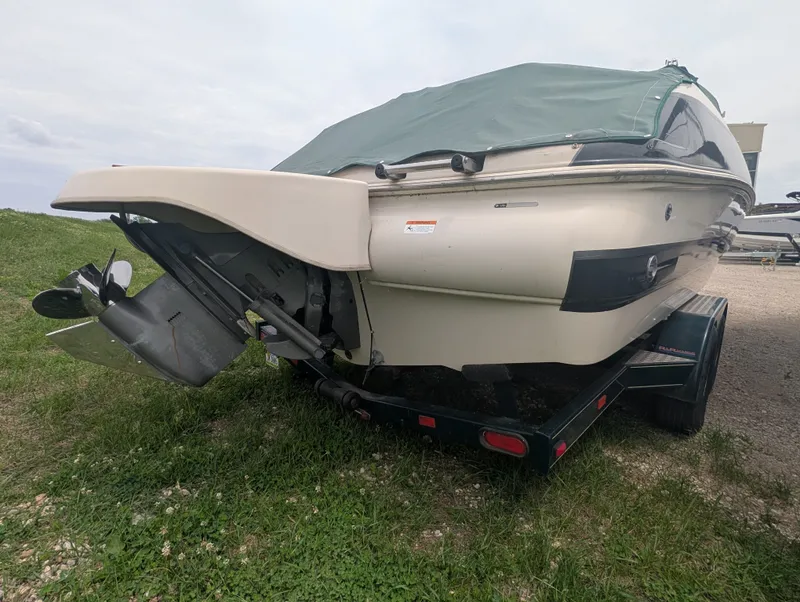 Slide: The Image of 2004 Larson Escape 234 boat on trailer, green cover. - 6