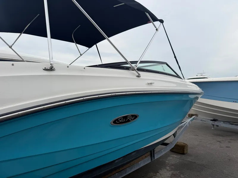 Slide: The Image of A Sea Ray SPX 230 Outboard boat on a trailer, featuring a blue hull and black canopy. - 1
