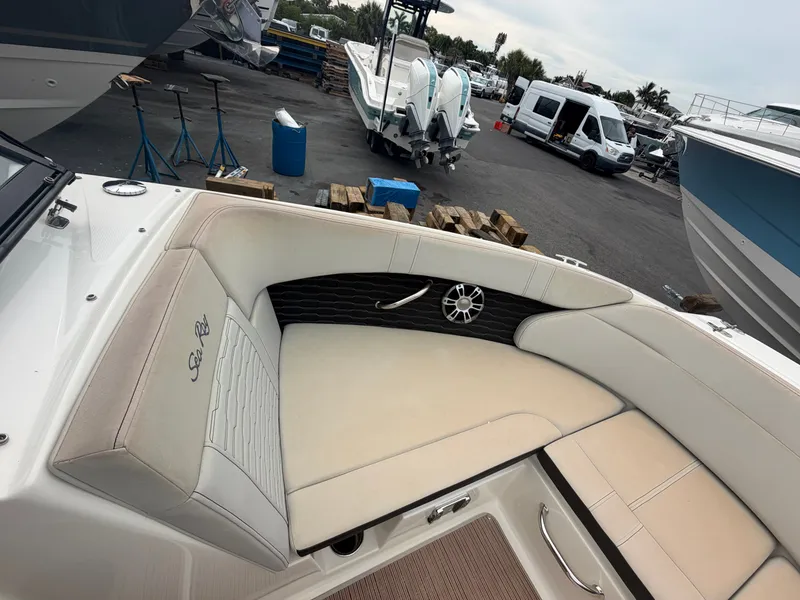 Slide: The Image of The interior of a Sea Ray SPX 230 Outboard boat with beige seating at a marina. - 18