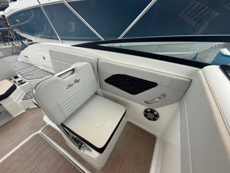 Slide: The Image of Interior view of a Sea Ray SPX 230 Outboard with white seating and wood flooring. - 19