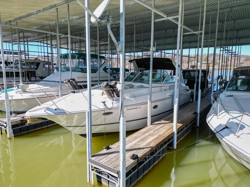 The Image of 2005 Cruisers Yachts 370 Express docked in a marina under a covered structure. - 0