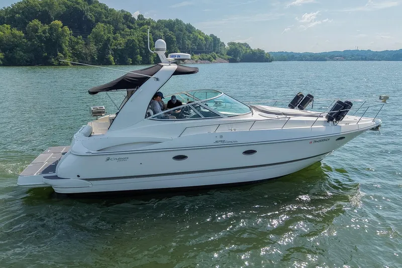 Slide: The Image of 2005 Cruisers Yachts 370 Express on a serene lake with lush green shoreline. - 10