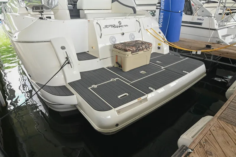 Slide: The Image of 2005 Cruisers Yachts 370 Express docked, featuring spacious swim platform and storage. - 18