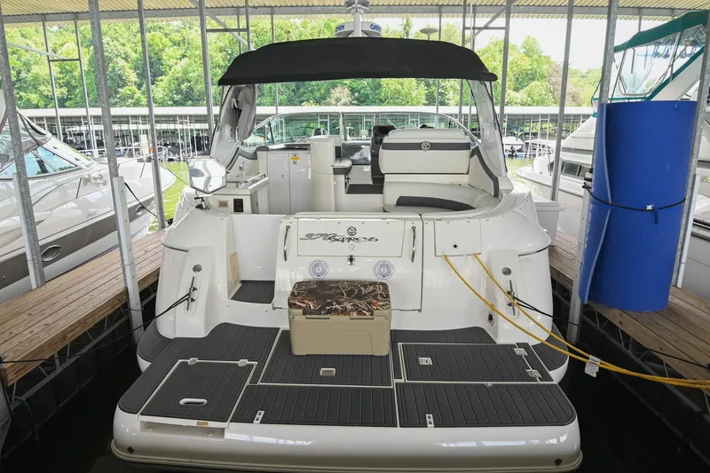 The Image of 2005 Cruisers Yachts 370 Express docked, showcasing spacious deck and seating area. - 2