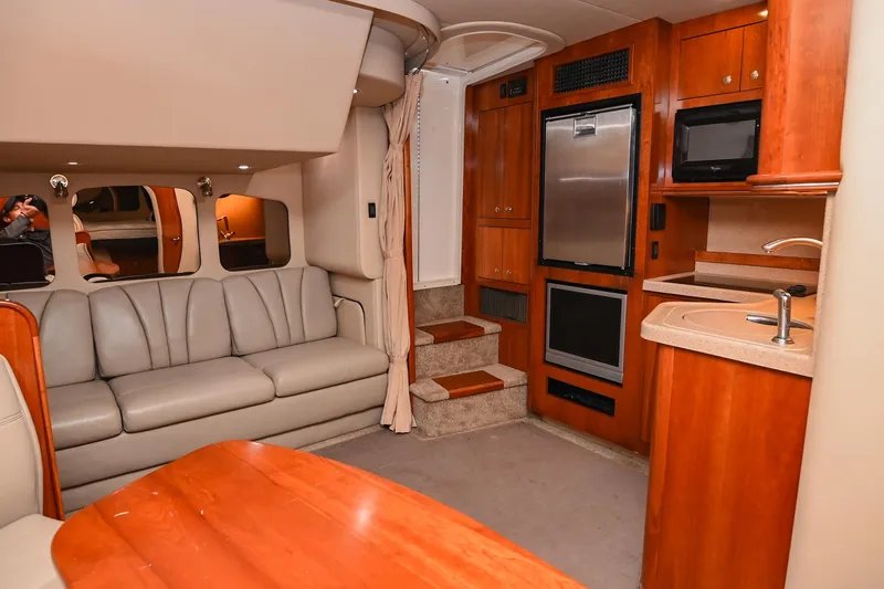 Slide: The Image of 2005 Cruisers Yachts 370 Express interior with sofa, kitchenette, and wooden cabinetry. - 30