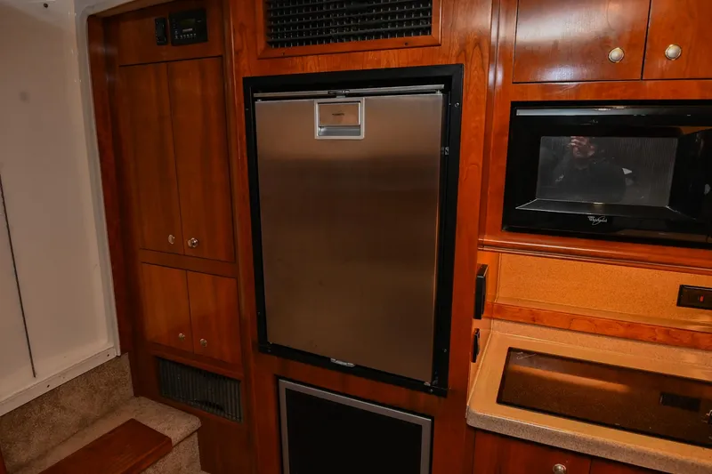 Slide: The Image of 2005 Cruisers Yachts 370 Express interior kitchen with fridge and microwave. - 32