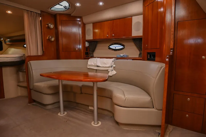 Slide: The Image of 2005 Cruisers Yachts 370 Express interior with curved seating and wooden table. - 37