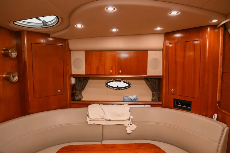 Slide: The Image of 2005 Cruisers Yachts 370 Express interior with wood cabinetry and circular seating area. - 39