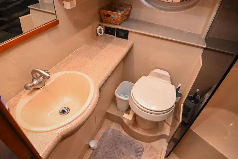 Slide: The Image of 2005 Cruisers Yachts 370 Express bathroom with sink, toilet, and storage basket. - 43