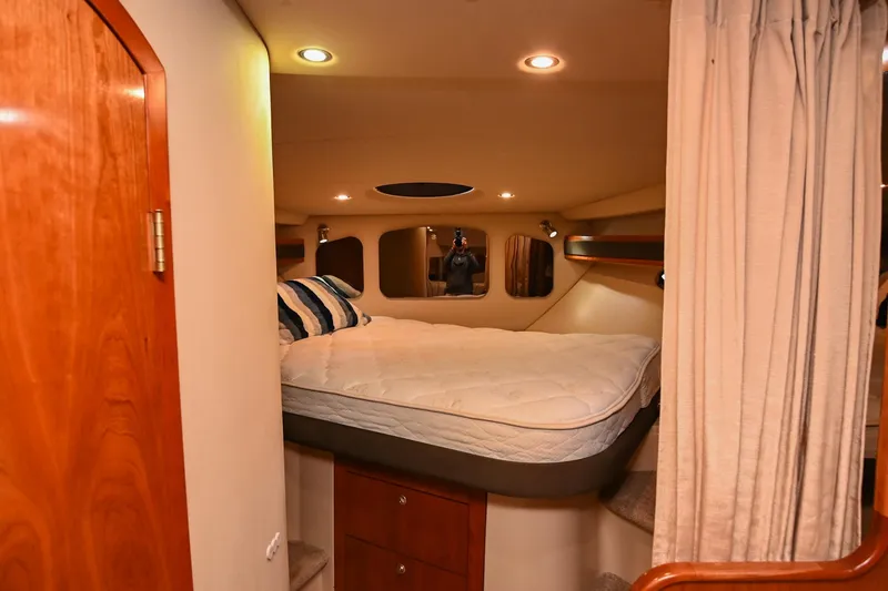 Slide: The Image of 2005 Cruisers Yachts 370 Express cabin interior with bed and wooden accents. - 46