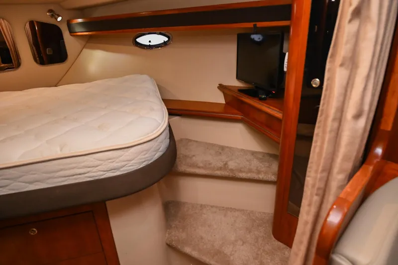 Slide: The Image of 2005 Cruisers Yachts 370 Express cabin interior with bed and carpeted steps. - 48