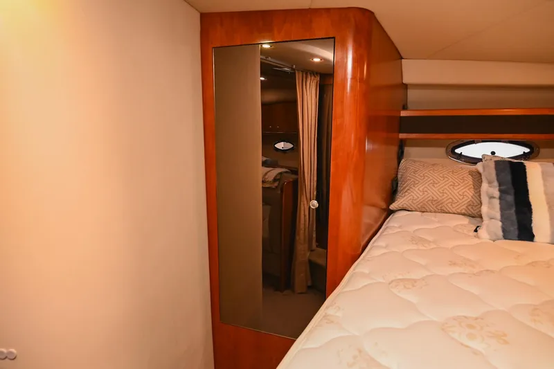 Slide: The Image of 2005 Cruisers Yachts 370 Express cabin with bed, mirror, and porthole window. - 49