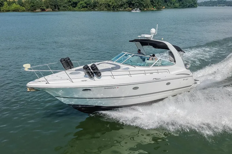 Slide: The Image of 2005 Cruisers Yachts 370 Express cruising on a serene lake with lush greenery. - 5