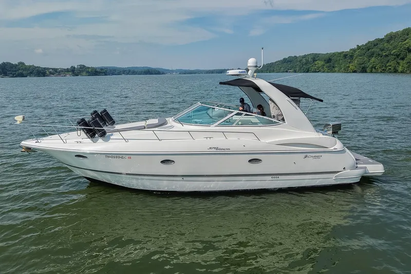 Slide: The Image of 2005 Cruisers Yachts 370 Express on a serene lake with lush green shoreline. - 7