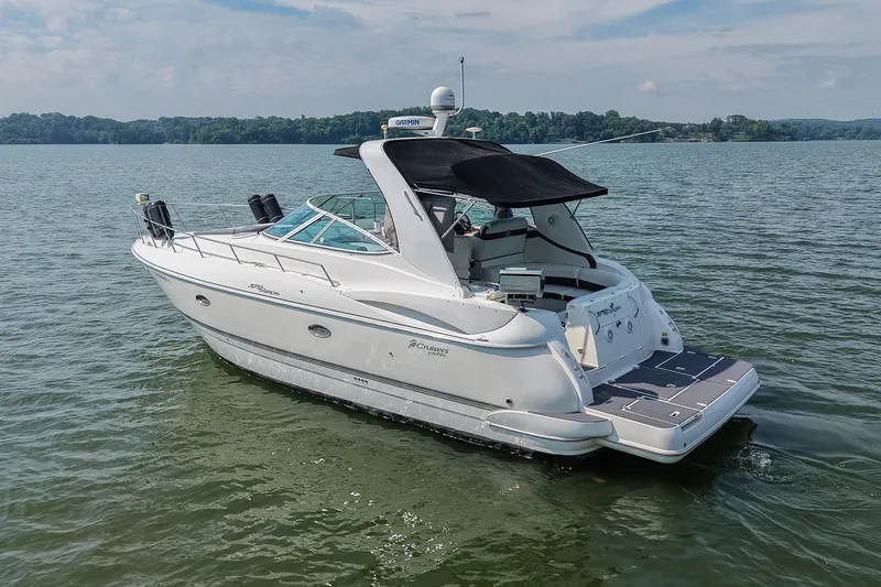 Slide: The Image of 2005 Cruisers Yachts 370 Express on serene lake, featuring sleek design and black canopy. - 8