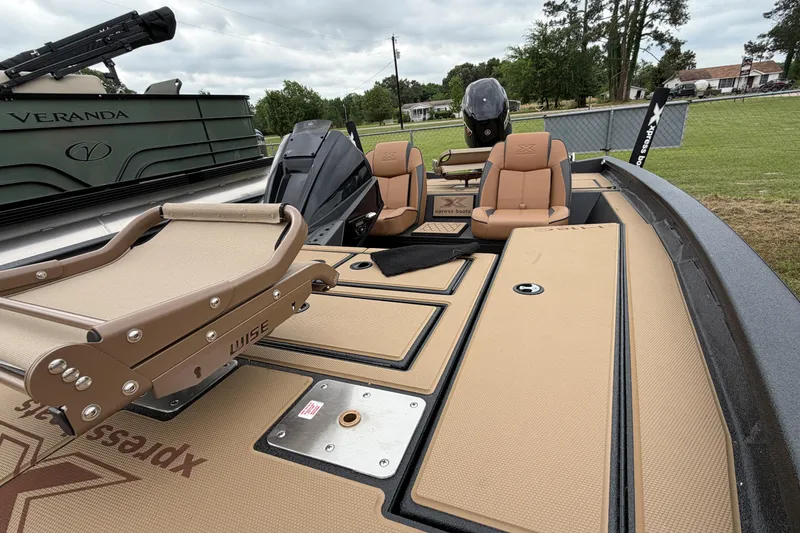 Slide: The Image of 2026 Xpress H18 Bass boat interior with tan seating and deck, featuring Wise accessories. - 5