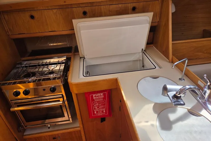 Slide: The Image of Galley kitchen with stove/oven, fridge, sink, and storage. - 6