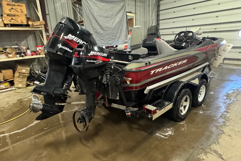 Slide: The Image of 2002 Tracker Targa 2000 boat with dual Mercury engines in a garage setting. - 3